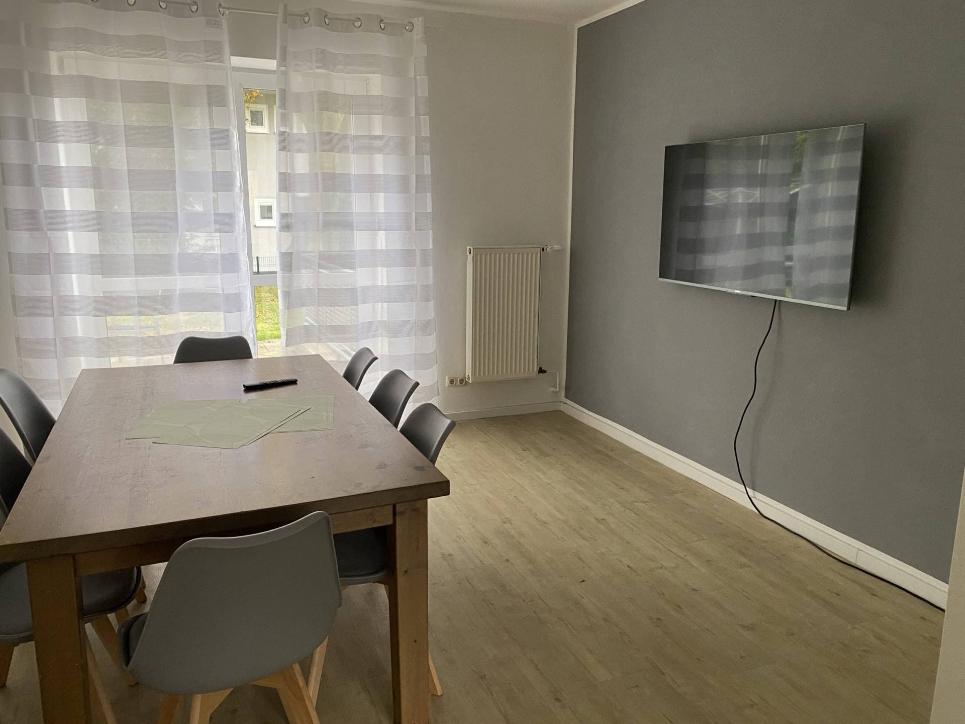 Wohn- und Essbereich mit Esstisch und TV im Monteurzimmer Herford